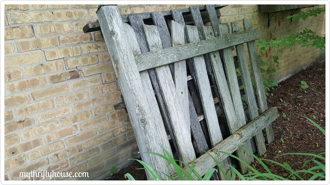Old fence and pallets used to make an outdoor dartboard.