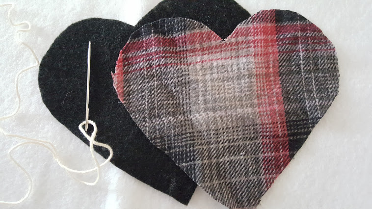 Sewing the plaid flannel puffy heart Valentines with some embroidery thread.