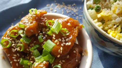 Whole30 orange chicken sprinkled with sesame seeds and green onions